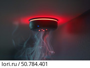 Smoke detector flashing red detecting a fire. Стоковое AI-изображение, AI-художник Иван Рябоконь / Фотобанк Лори