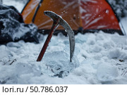 Ice axe and tent in snowy winter camping scene. Стоковое AI-изображение, AI-художник Иван Рябоконь / Фотобанк Лори