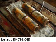 Two rolled up maps resting on wooden table showing plans for adventure. Стоковое AI-изображение, AI-художник Иван Рябоконь / Фотобанк Лори