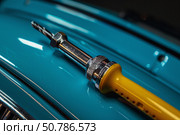 Spot welding tool resting on restored classic car body panel. Стоковое AI-изображение, AI-художник Иван Рябоконь / Фотобанк Лори