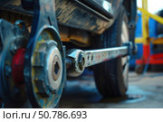 Mechanic using torque wrench for wheel alignment and maintenance. Стоковое AI-изображение, AI-художник Иван Рябоконь / Фотобанк Лори