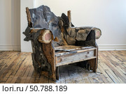 Deconstructed armchair exposing inner materials on hardwood floor. Стоковое AI-изображение, AI-художник Иван Рябоконь / Фотобанк Лори