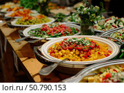 Catering buffet food service with vegetable salads displayed on table. Стоковое AI-изображение, AI-художник Иван Рябоконь / Фотобанк Лори