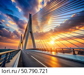 A majestic cable-stayed bridge at sunset, displaying a blend of structural engineering and scenic beauty as the sun sets in the background. Стоковое AI-изображение, AI-художник Ольга Игнашина / Фотобанк Лори