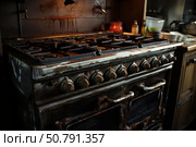 Old rusty stove showing signs of neglect in messy kitchen. Стоковое AI-изображение, AI-художник Иван Рябоконь / Фотобанк Лори