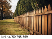 Wooden picket fence protecting green grass along suburban street. Стоковое AI-изображение, AI-художник Иван Рябоконь / Фотобанк Лори