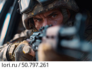 Российский военнослужащий в полной боевой экипировке и защитном шлеме прицеливается из автомата на фоне военной техники в зоне боевых действий. Стоковое AI-изображение, AI-художник ArtVladZ / Фотобанк Лори