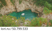 Boats float in a hidden rocky cove on sunny summer day in Capri Island, Italy. Стоковое видео, видеограф Igor Tichonow / Фотобанк Лори