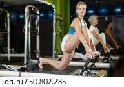 Athletic woman doing leg exercises on reformer. Стоковое фото, фотограф Яков Филимонов / Фотобанк Лори