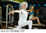 Mature woman actively doing Pilates exercises. Стоковое фото, фотограф Яков Филимонов / Фотобанк Лори
