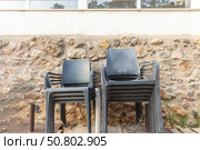 A group of Plastic black chair on the orange and yellow stones background. Стоковое фото, фотограф Татьяна Куклина / Фотобанк Лори