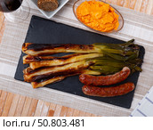 Catalan roasted calcots with romesco sauce and grilled butifarra. Стоковое фото, фотограф Яков Филимонов / Фотобанк Лори