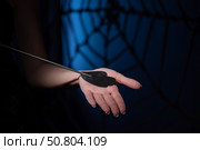 An unrecognizable woman demonstrates an elegant thin leather strip whip in a dark bedroom. Close-up of female hands with a bdsm toy. Pain and pleasure.Adult toy for slaps. Стоковое фото, фотограф Михаил Решетников / Фотобанк Лори