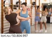 Young girl practicing self-defense techniques in pair. Стоковое фото, фотограф Яков Филимонов / Фотобанк Лори