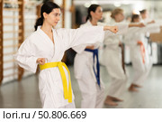 Young woman practicing punches standing in row with others. Стоковое фото, фотограф Яков Филимонов / Фотобанк Лори