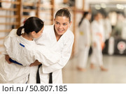 Positive young girl applying throwing technique during judo classes. Стоковое фото, фотограф Яков Филимонов / Фотобанк Лори
