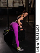 Young beautiful woman doing one-arm dumbbell back exercise on bench. Athletic girl in the gym. Exercises for the latissimus dorsi. Стоковое фото, фотограф Михаил Решетников / Фотобанк Лори