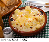 Tasty baked cauliflower with bechamel sauce in clay pot at table. Стоковое фото, фотограф Яков Филимонов / Фотобанк Лори