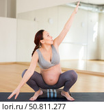 Pregnant woman is engaged in yoga. Deep Squats or Mama Squats or Malasana. Стоковое фото, фотограф Татьяна Яцевич / Фотобанк Лори