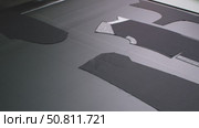 Details of a man's black jacket laid out on a tape for dubbing at a garment factory. Стоковое видео, видеограф Дмитрий Нечаев / Фотобанк Лори