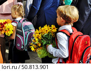 Первоклассники, девочка и мальчик, входят в толпе в школу. Москва (2018 год). Редакционное фото, фотограф Вера Смолянинова / Фотобанк Лори