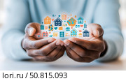 Concept: Home Ownership and Dreams: Hand holding a collection of home icons, symbolizing dreams and the journey to owning a house. Стоковое AI-изображение, AI-художник Данила Большаков / Фотобанк Лори