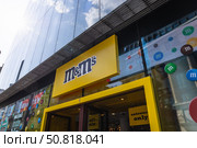 M and M London flagship storefront and logo, Leicester Square. London, UK, 2 June 2024. Редакционное фото, фотограф Zydrius Tartenis / Фотобанк Лори