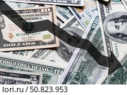 Arrow down on the background of dollar bills. The concept of inflation, depreciation of the dollar or the US economy. Стоковое фото, фотограф Емельянов Евгений Викторович / Фотобанк Лори