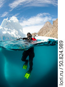 Diver in front of an iceberg, Astrolabe Island, Antarctic Peninsula, Antarctica. Стоковое фото, фотограф Steve Jones/Stocktrek Images / ТАСС / Фотобанк Лори