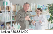 Man with heart pain choosing pills with help of pharmacist. Стоковое видео, видеограф Яков Филимонов / Фотобанк Лори