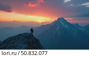 Amazing and inspiring romantic sunset over high mountains. Two people hike and camp, walk on crest edge of mountain peak, reaching goal or finish line. Motivational moment for achi. Стоковое AI-видео, аниматор Sergey Grishin / Фотобанк Лори