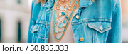 Fashion accessory: A collection of blue beaded necklaces and chains worn with a blue jean jacket, perfect for lifestyle apparel advertisement. Стоковое AI-изображение, AI-художник Данила Большаков / Фотобанк Лори