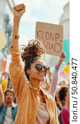Activism Rally: Woman's Upraised Fist Symbolizes Solidarity and Empowerment at a Public Demonstration. Стоковое AI-изображение, AI-художник Данила Большаков / Фотобанк Лори