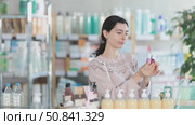 Female shopper chooses best nailpolish in supermarket. Стоковое видео, видеограф Яков Филимонов / Фотобанк Лори