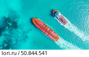 Aerial nautical transport: view from above showcases two vessels in a vibrant turquoise ocean, depicting maritime commerce and seagoing trade. Стоковое AI-изображение, AI-художник Данила Большаков / Фотобанк Лори