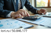 Человек работает с калькулятором и ноутбуком в офисе / A man works with a calculator and laptop in an office. Стоковое AI-изображение, AI-художник Валерий Лукин / Фотобанк Лори