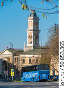 Budapest, Hungary - April 4, 2025: Bright blue Bus dich weg coach parked near the historic tower of the Buda Castle District. Редакционное фото, фотограф Софья Соломонова / Фотобанк Лори
