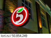 Russia, Kaluga - DECEMBER 27, 2021: Luminous logo of the Russian retailer Pyaterochka on a wall in night. Редакционное фото, фотограф Емельянов Евгений Викторович / Фотобанк Лори