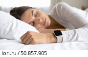 Woman peacefully sleeping with a smartwatch on her wrist representing sleep tracking, health tech, modern wellness, and restful night monitoring. Стоковое AI-изображение, AI-художник Igor Tichonow / Фотобанк Лори