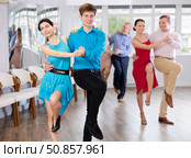 Cheerful young couple dancing playful jitterbug in dance studio. Стоковое фото, фотограф Яков Филимонов / Фотобанк Лори