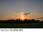 Закат солнца над полем с тюками сена на переднем плане. Стоковое фото, фотограф Алексей Линник / Фотобанк Лори
