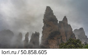 Misty mountain landscape. High pillars of rocks with steep slopes and sharp peaks are shrouded in clouds and fog. Green vegetation. China. Zhangjiajie National Forest Park. Avatar. Стоковое фото, фотограф Вера Ивановна Кубарева / Фотобанк Лори