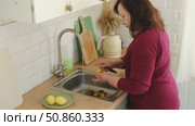 Senior active woman cooking lunch at home in modern kitchen. Healthy eating, food and culinary concept. Hands of old lady with knife chopping vegetables, grating carrots. Elderly female cook a soup. Стоковое видео, видеограф Марина Демидюк / Фотобанк Лори