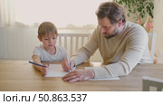 Dad teaches his son writing and counting. Kids primary education. Children learn, study in home school. Daddy male helping teaching little child boy support studying, learning homework. Knowledge day. Стоковое видео, видеограф Марина Демидюк / Фотобанк Лори