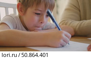 Dad teaches his son writing and counting. Kids primary education. Children learn, study in home school. Daddy male helping teaching little child boy support studying, learning homework. Knowledge day. Стоковое видео, видеограф Марина Демидюк / Фотобанк Лори