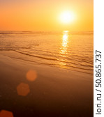 A colorful sunset or sunrise on the seaside with a sandy beach with impurities of volcanic ash. Mandrem, Goa, India. (2018 год). Стоковое фото, фотограф Емельянов Евгений Викторович / Фотобанк Лори