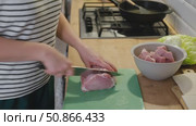 Female butcher cut raw meat with sharp knife at home kitchen. Woman cutting the chicken fillet in pieces for cooking. Preparing chopping food. Split poultry breast. Healthy lean meat, low cholesterol. Стоковое видео, видеограф Марина Демидюк / Фотобанк Лори