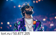 Rapper's Reverie: A Musical Artist in the Limelight, Adorned with Extravagance and Looking Upward. Стоковое AI-изображение, AI-художник Данила Большаков / Фотобанк Лори