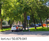Дворник подметает рядом с припаркованными автомобилями во дворе жилого дома, Москва. Редакционное фото, фотограф Мария Сергеева / Фотобанк Лори