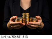 Hands holding stacks of golden cryptocurrency coins. Стоковое AI-изображение, AI-художник Иван Рябоконь / Фотобанк Лори